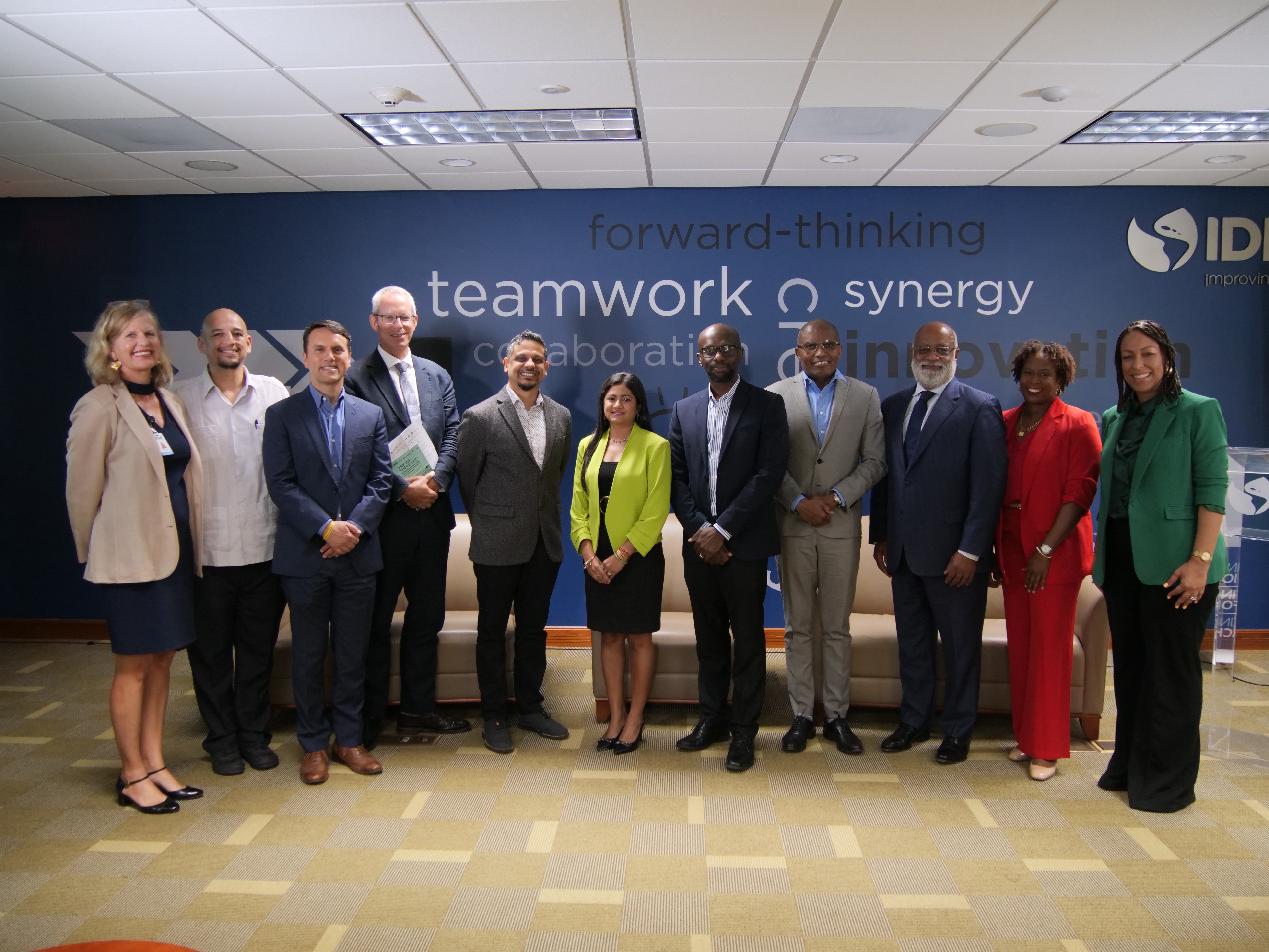 Group of Caribbean persons standing in business attire in an office space