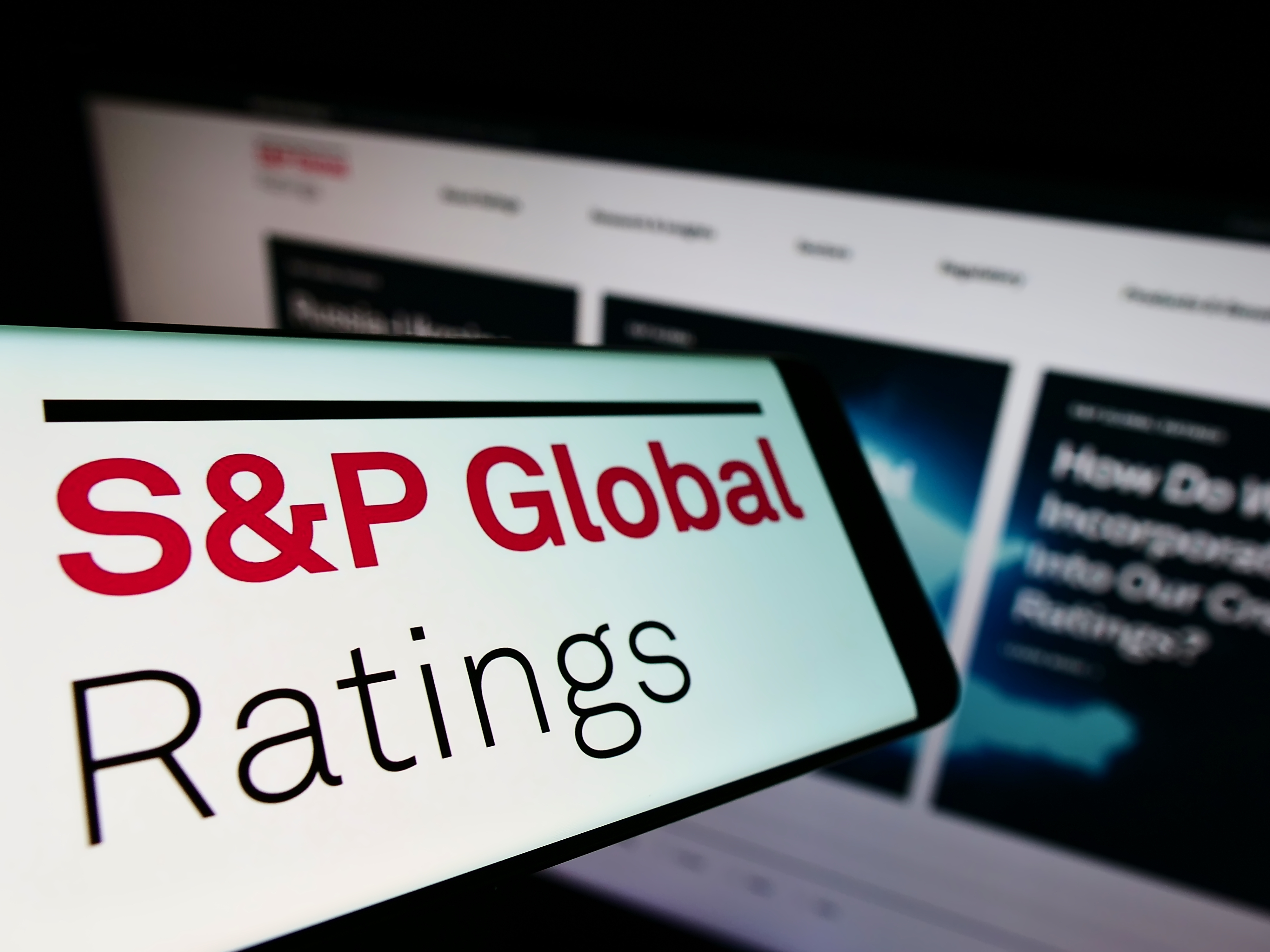 An image with the words S&P Global Ratings with a computer in the background 