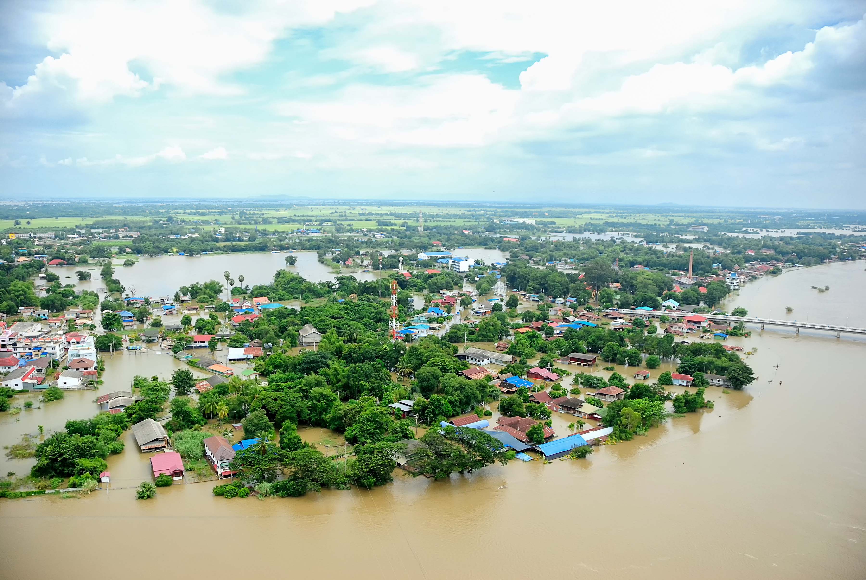 aerial shot of flooded town with only tops and tress and roof tops visible