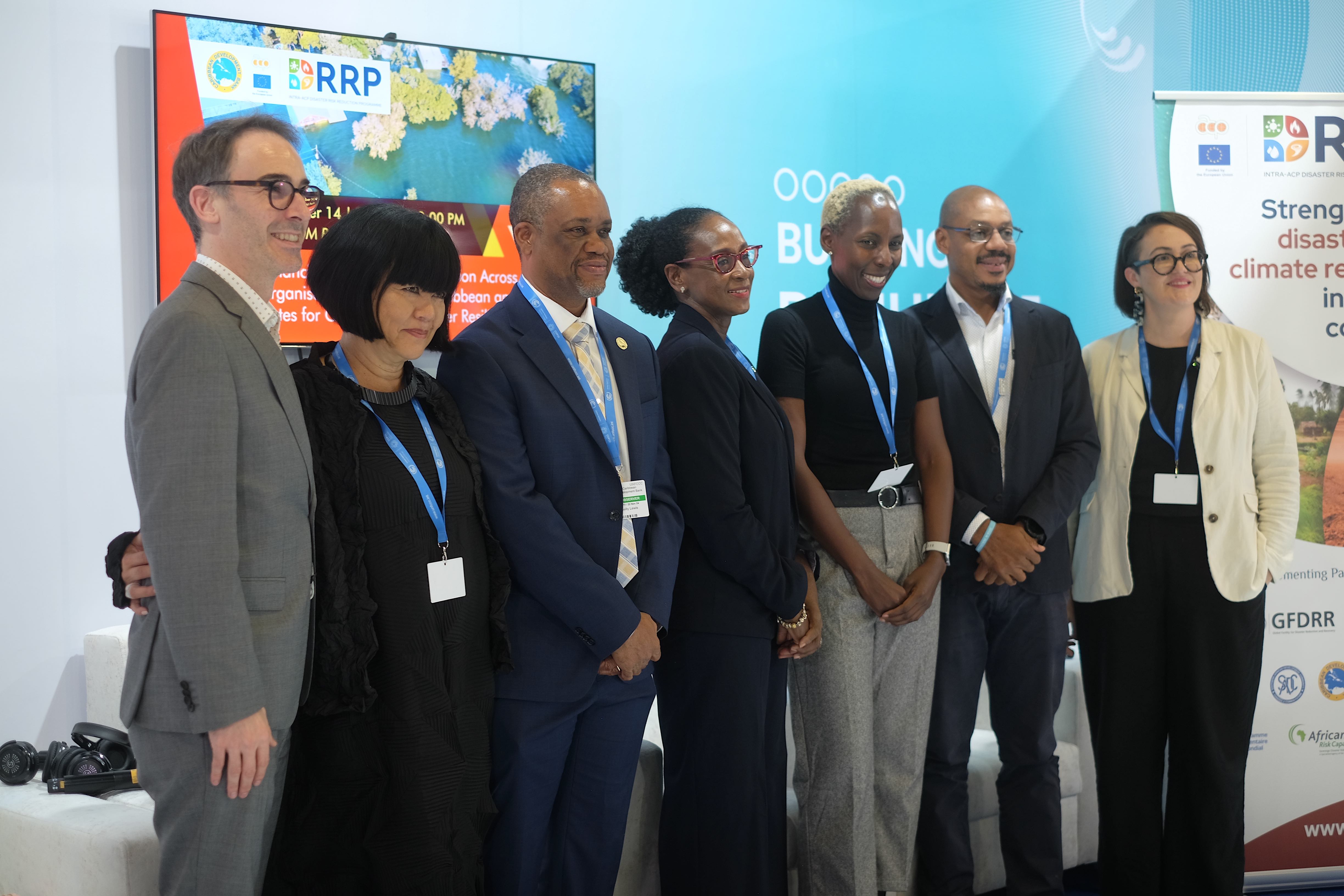 Panellists at the Enhancing Strategic Collaboration for Climate Disaster Resilience event stand together before a COP29 backdrop