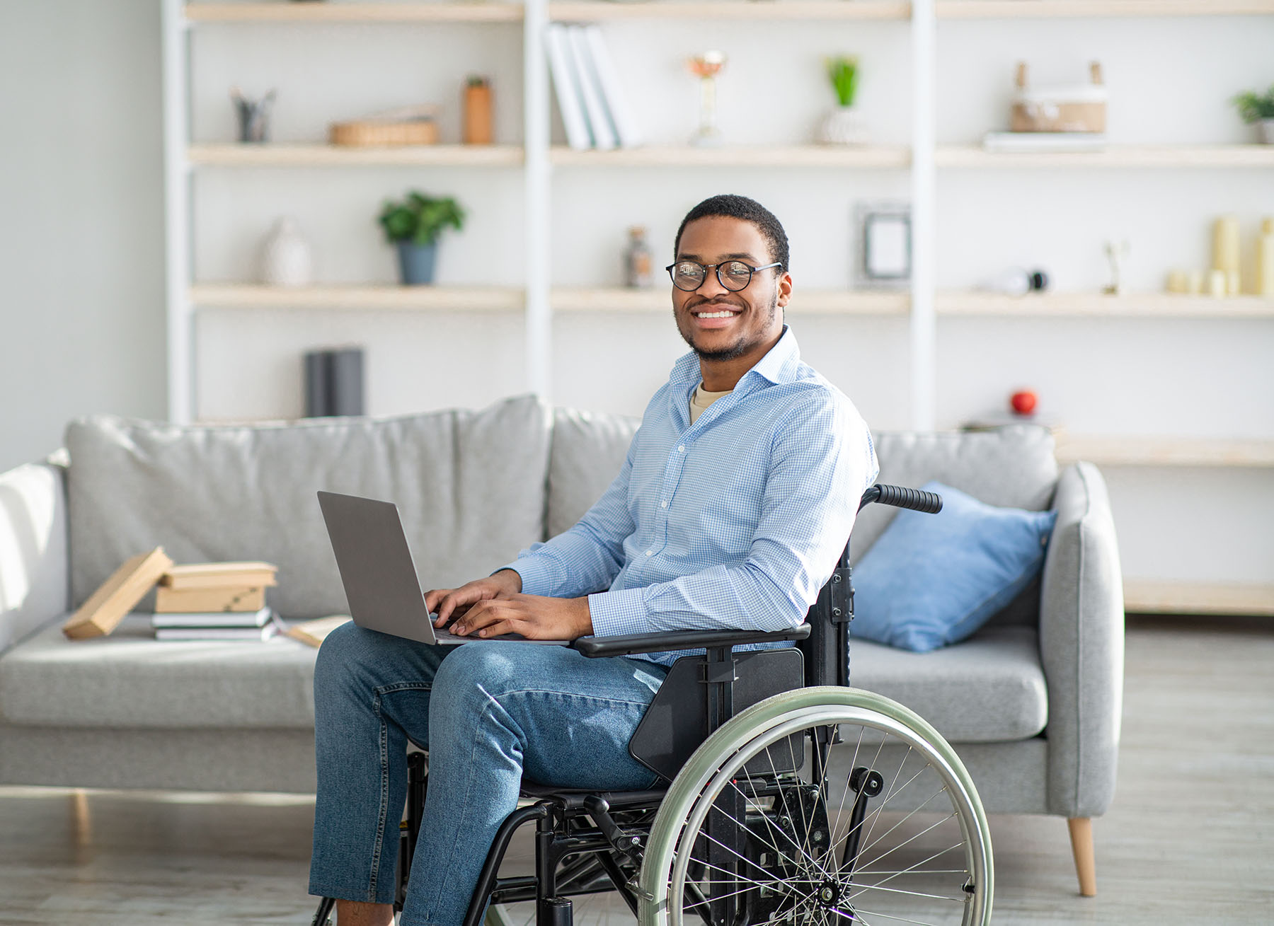 differently=abled young black man in wheelchair using laptop