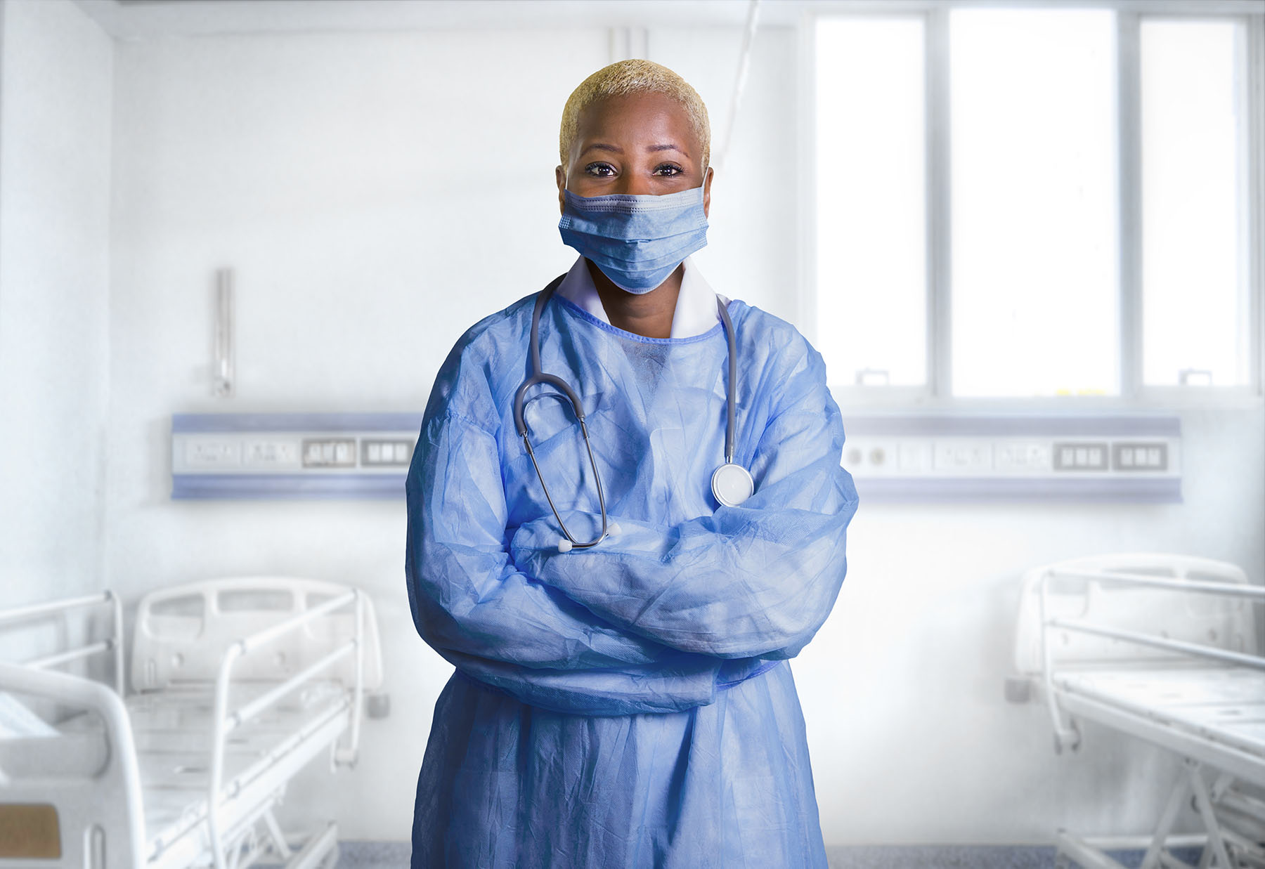 young attractive and confident black African American medicine doctor wearing face mask and blue scrubs