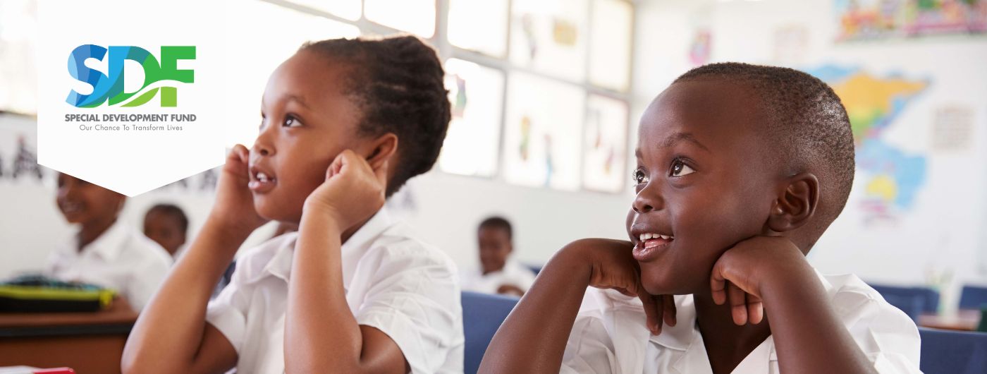 two black school children seated at desk looking forward and listening attentively