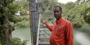 gentleman in red shirt with the Rio Cabre, Jamaica in the background