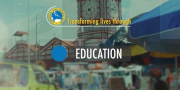 screen capture of video slide with city of Georgetown, Guayana as backdrop with the word education highlighted
