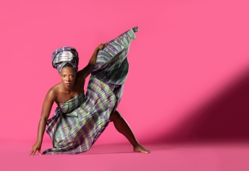 Black woman dancer in bent over pose with background and large shadow