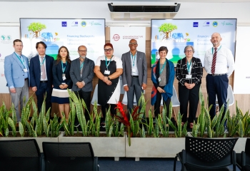 CDB's Hopeton Peterson and members of the MDB platform at the COP16 in Cali Colombia stand together on a platform