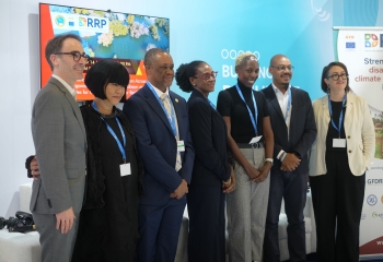 Panellists at the Enhancing Strategic Collaboration for Climate Disaster Resilience event stand together before a COP29 backdrop