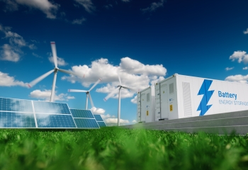 solar panels and wind turbines in foliage against a bright blue sky