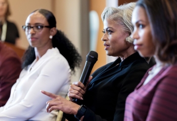 Mature black businesswoman gestures while answering a question during a discussion