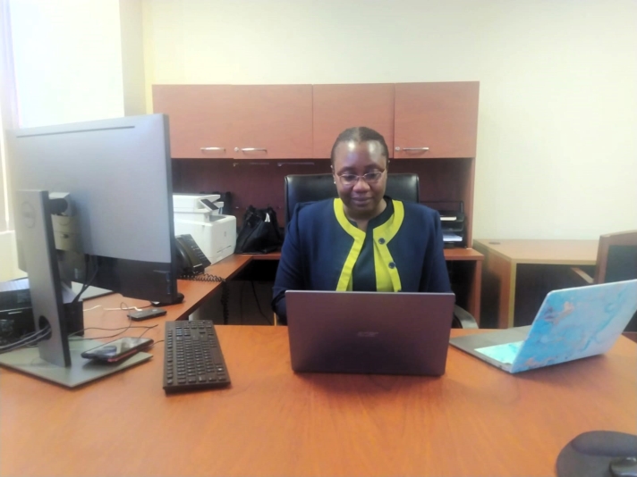 Black woman sitting at desk in business attire 