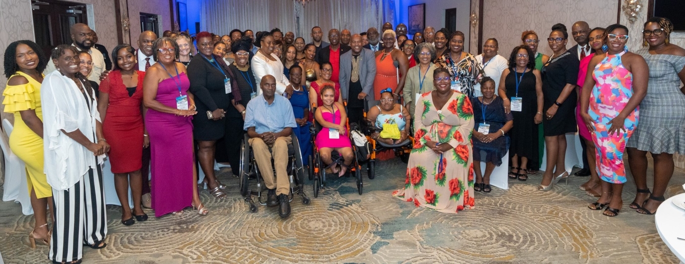 A group of black disabled persons in elegant colourful clothing in a ballroom 